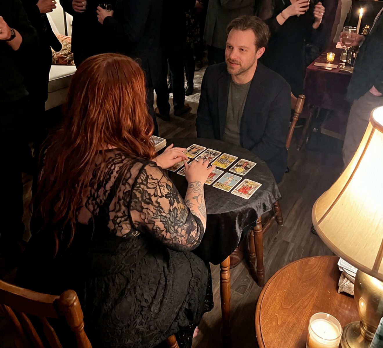 A tarot reading at a Virgo Room party, guests gathered behind